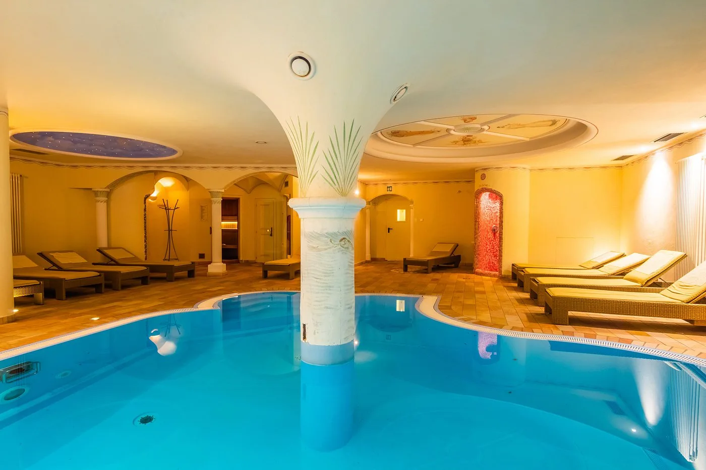 Piscina interna riscaldata con colonna centrale e illuminazione soffusa