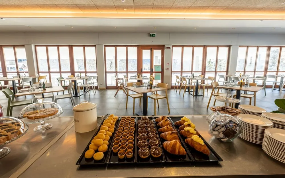 Buffet colazione con cornetti, dolci e pasticcini nella sala ristorante luminosa