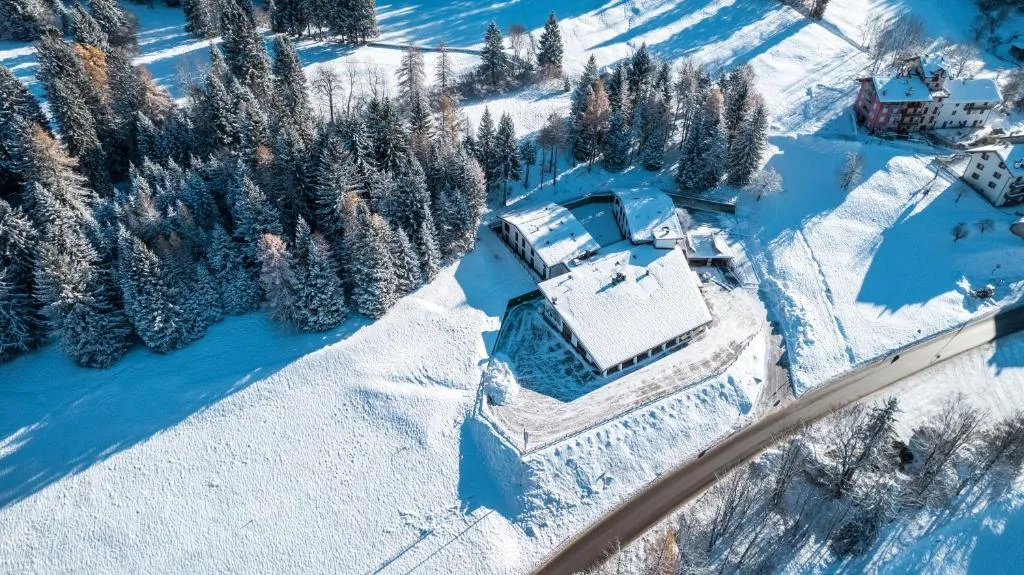 Veduta aerea invernale dell'Hotel Casa Alpina circondato da neve e boschi
