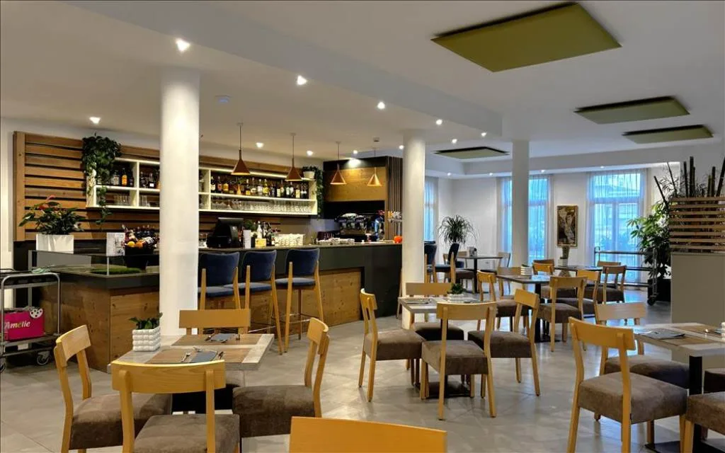 Area bar e ristorante con bancone in legno, tavoli e sedie