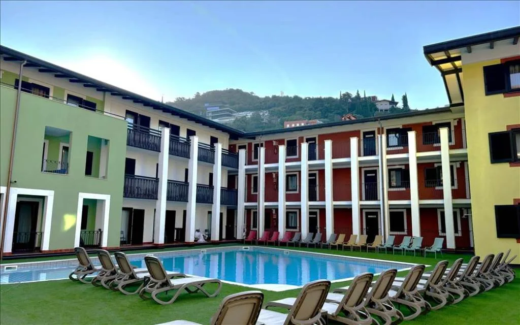 Cortile interno dell'hotel con piscina, lettini e edifici colorati