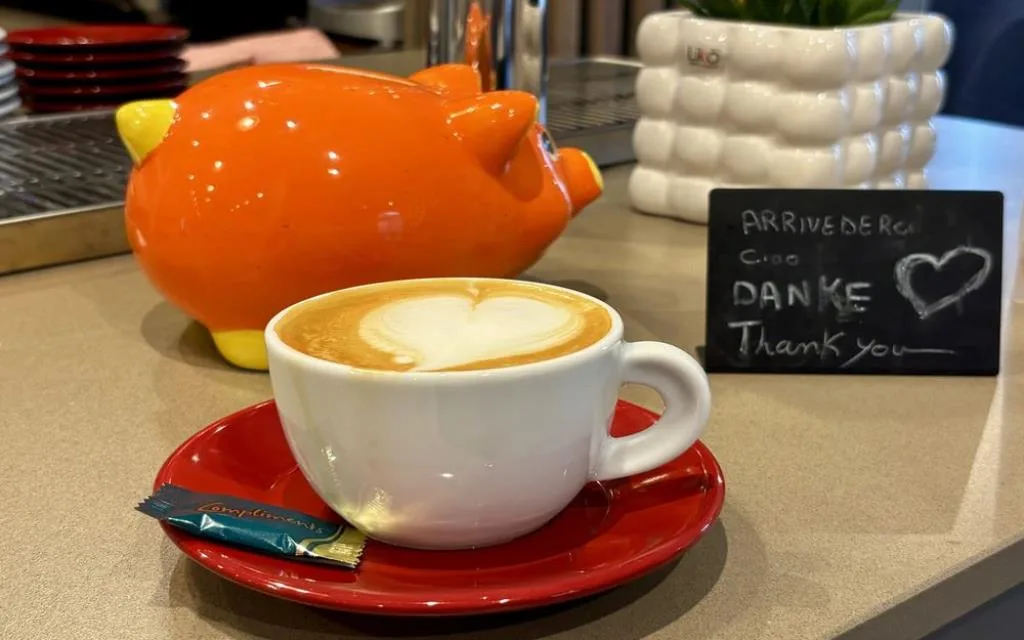 Cappuccino con decorazione a cuore servito al bancone del bar